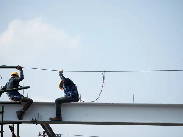 Man Working on the Working at height on construction site with blue sky